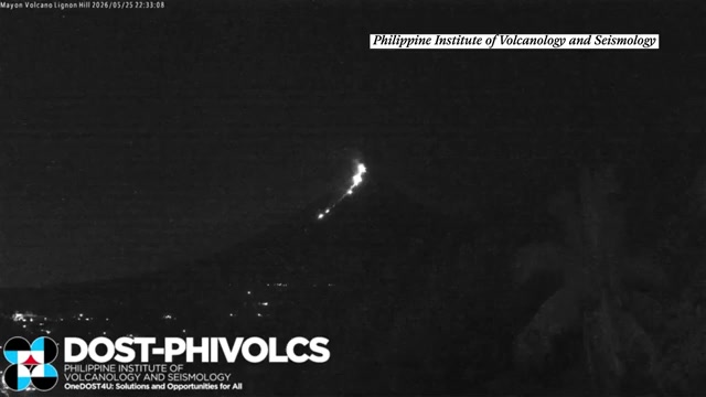 Moment meteor flies through sky beside erupting volcano