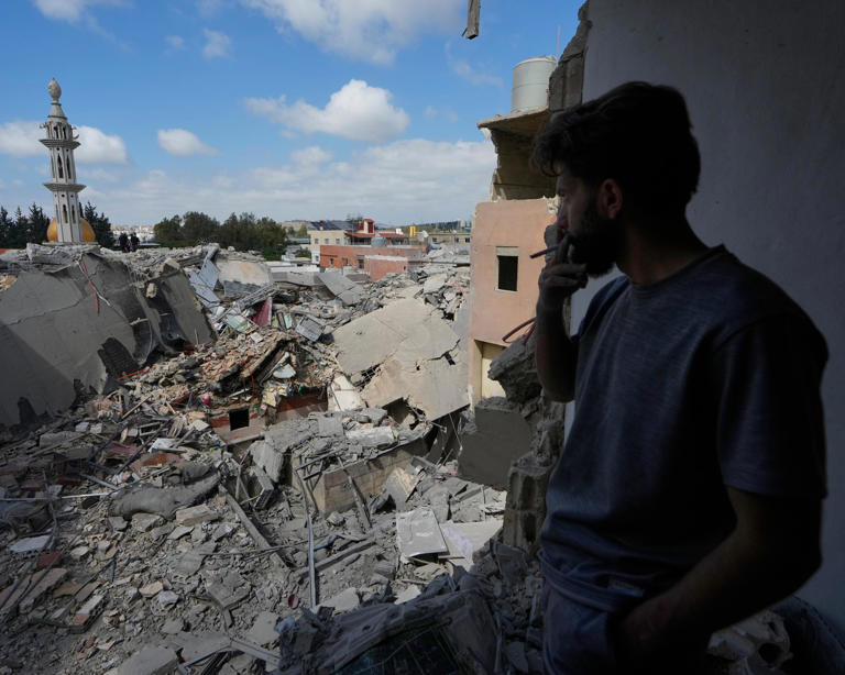 A man looks at a building destroyed by an Israeli airstrike, in southern Lebanon.