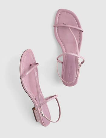 Pair of minimalist strappy sandals with a flat sole and thin, stylish straps, suitable for casual or summer wear