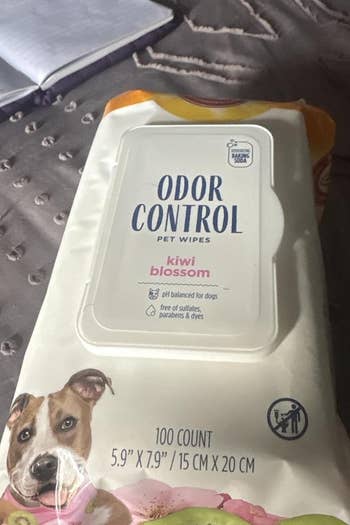 Pet wipes package on bed with open notebook; labeled