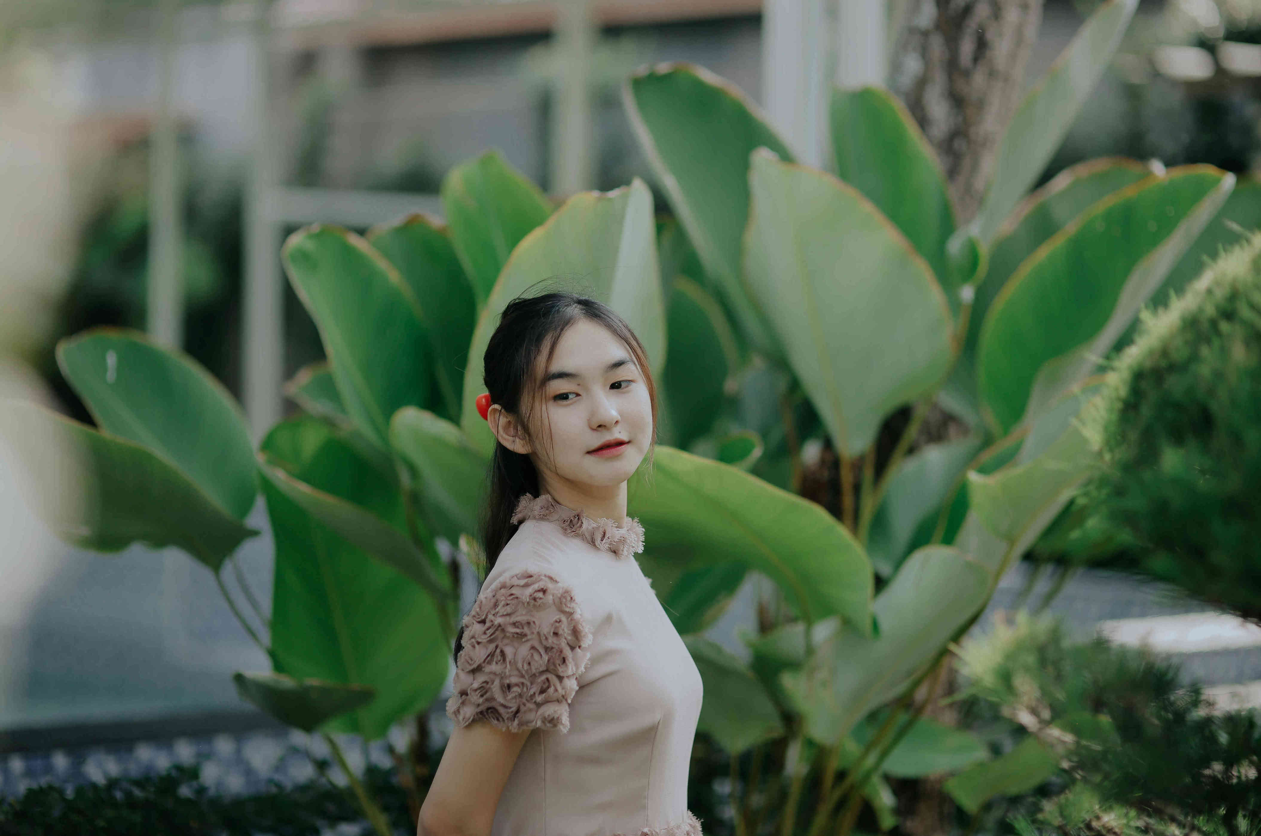 满园翠色铺就天然取景框，柔雾浅粉裙装点缀红饰，草木环绕抒写清幽自然氛围感