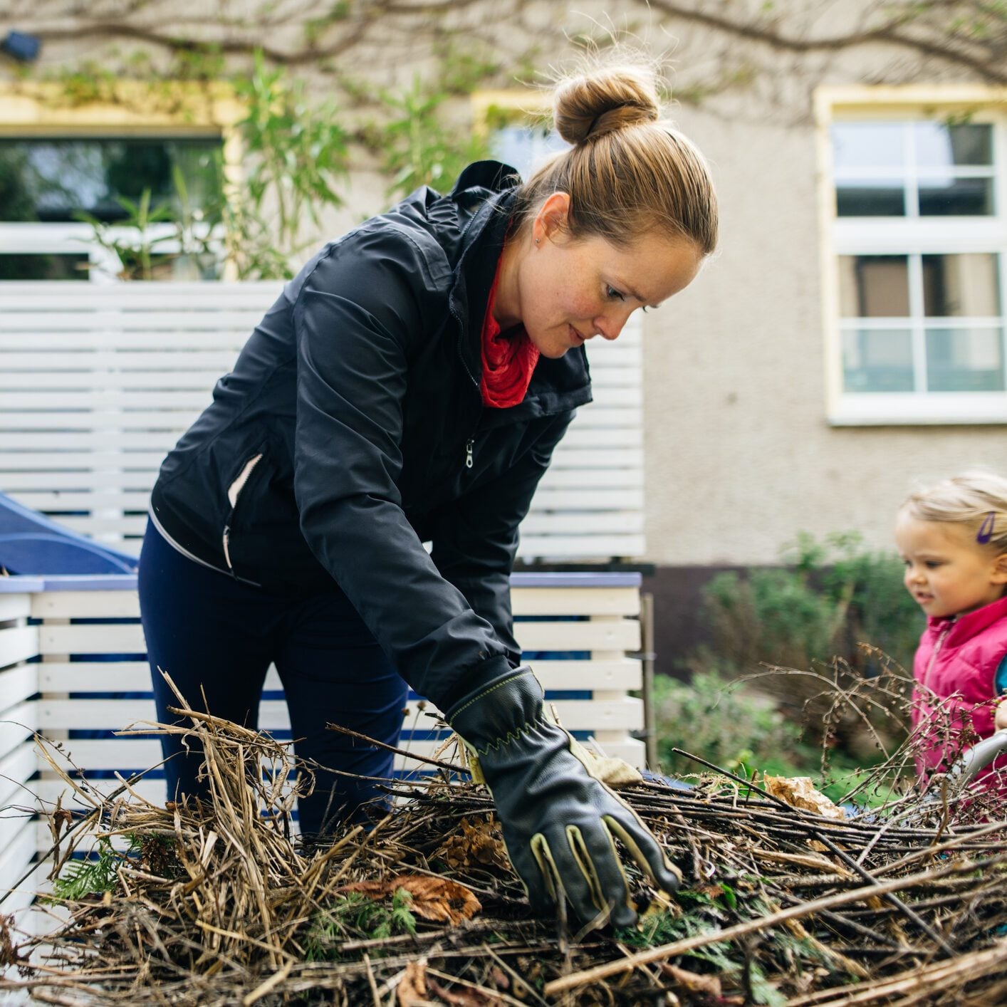 Cheerful woman putting dirt and compost into a DIY raised bed.