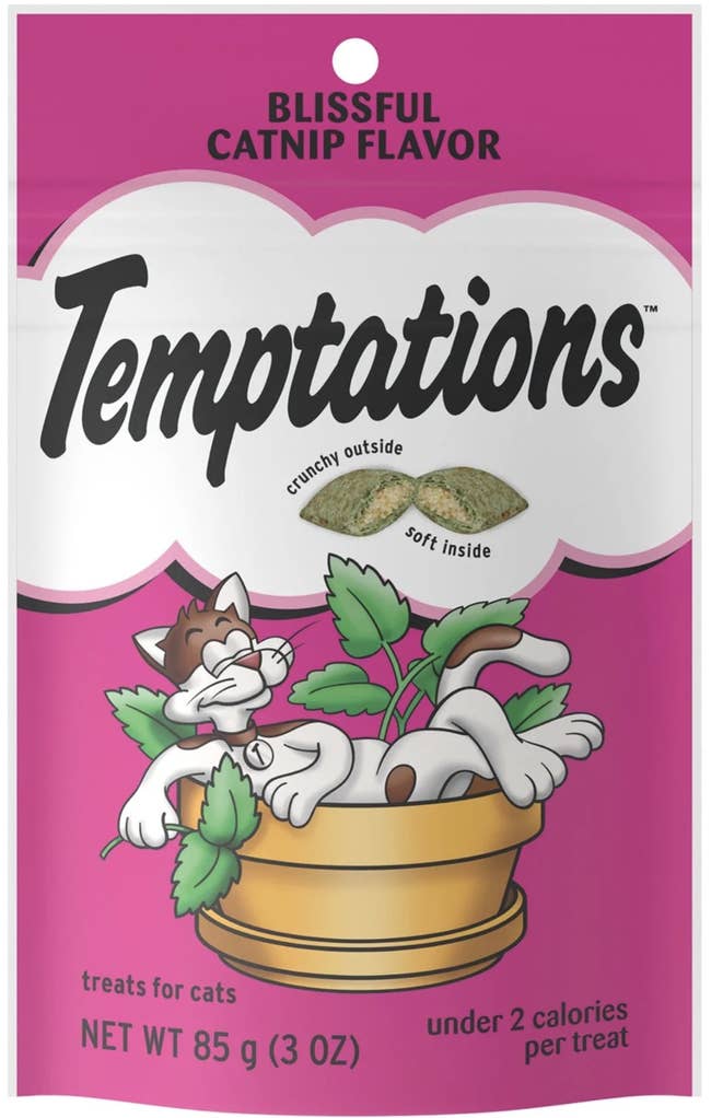 Cat sniffing a bed as a hand sprays it with Pet Craft catnip spray from a bottle
