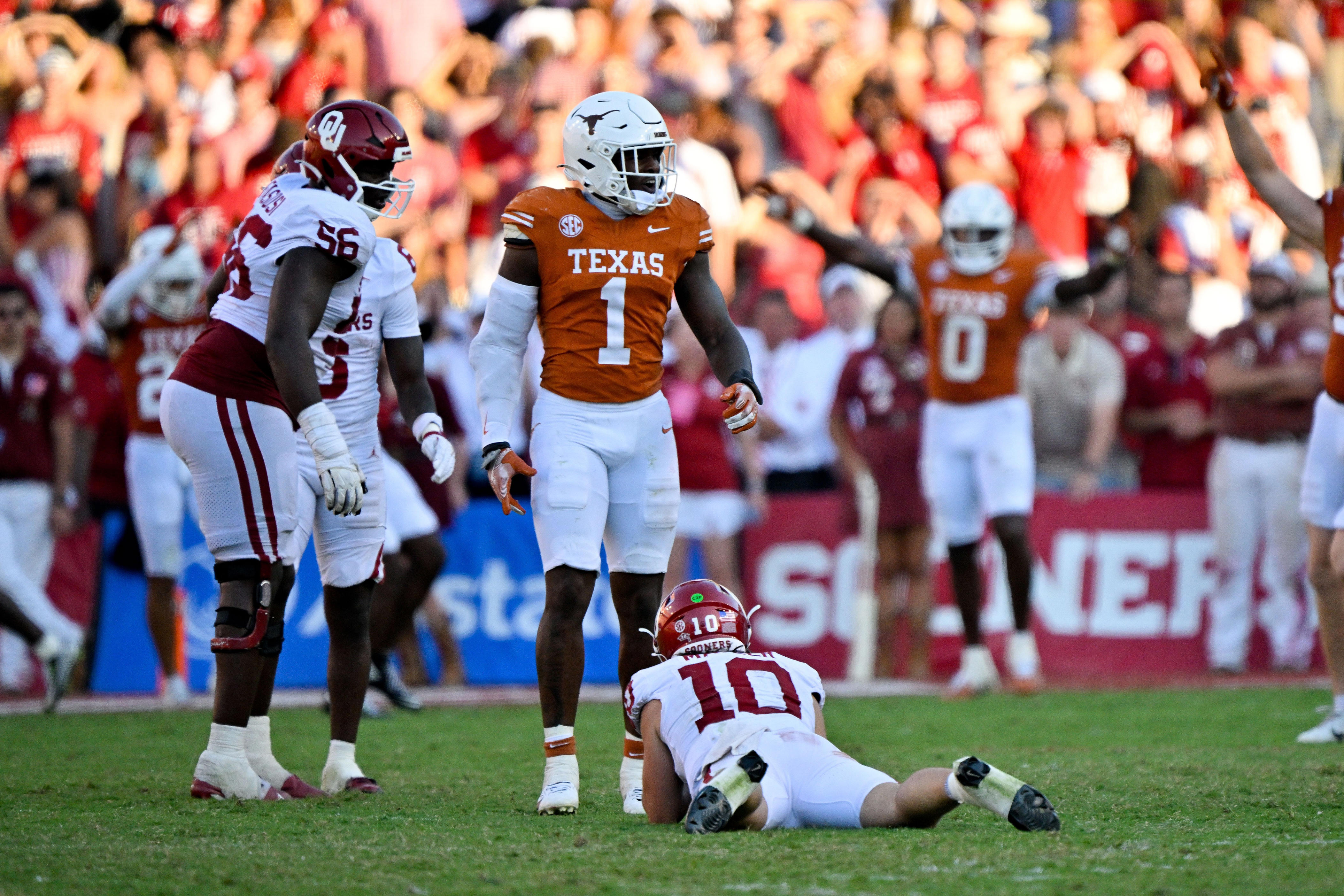 Oct 11, 2025; Dallas, Texas, USA; Texas Longhorns defensive end Colin Simmons (1) stands over Oklahoma Sooners quarterback John Mateer (10) after Mateer is sacked during the second half at the Cotton Bowl. Mandatory Credit: Jerome Miron-Imagn Images