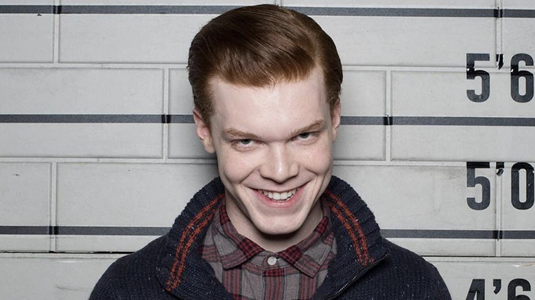 Cameron Monaghan as Jerome Valeska with ginger hair, and wearing a dark sweater and a red plaid shirt.