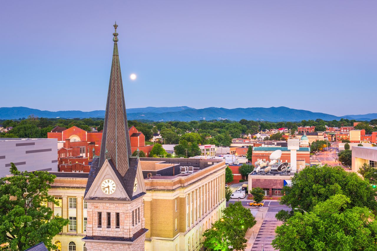 Cityscape of Roanoke Virginia featuring a church spire and distant mountains