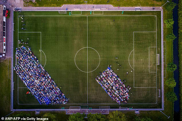 An aerial shot of Muslim worshippers taking part in prayers on a football ground in the Netherlands