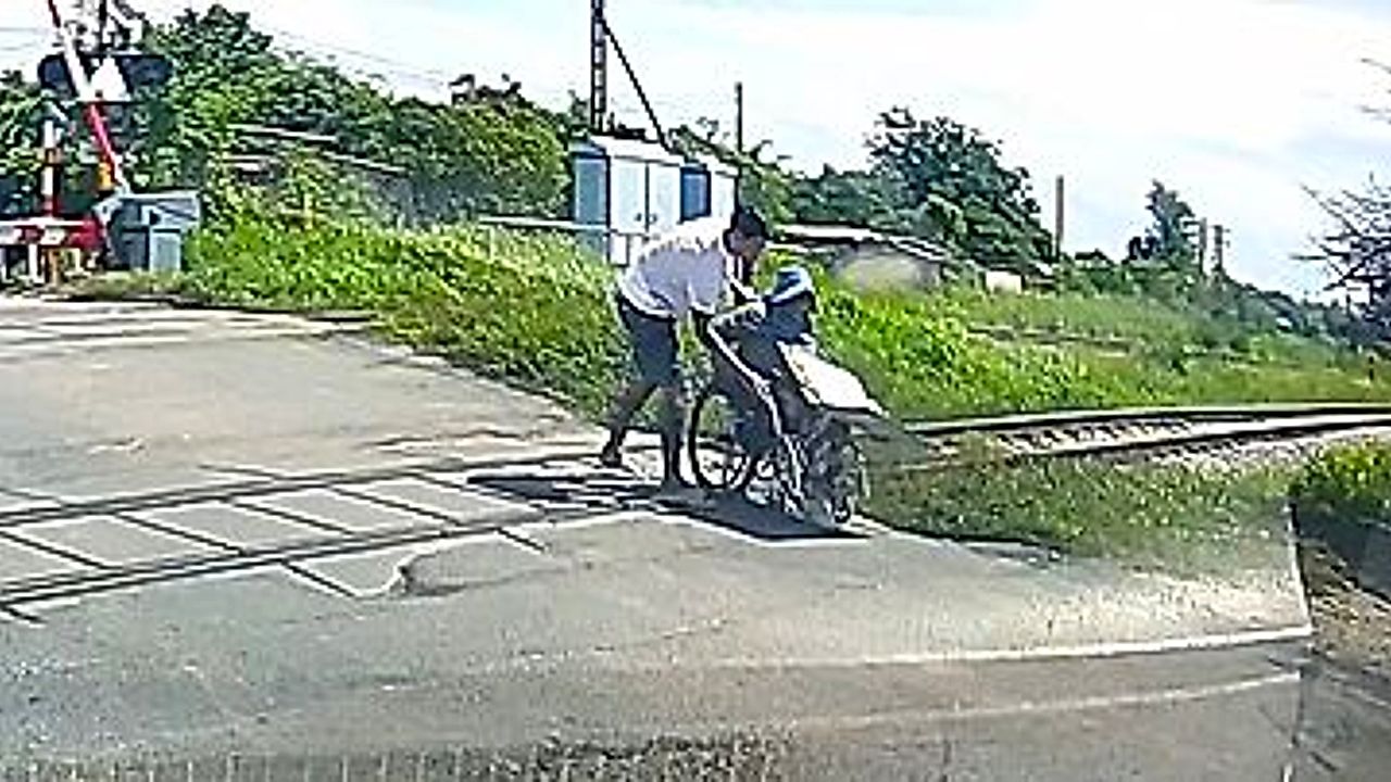 Driver leaps out of car to rescue wheelchair vendor stuck on railway ...