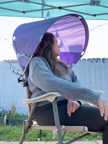 reviewer sitting underneath the shade attached to a chair