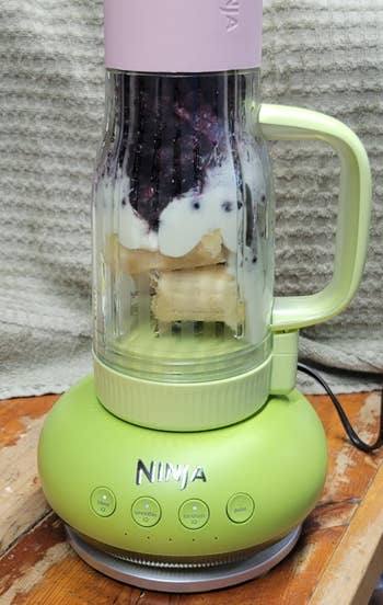 the blender in the watermelon bubblegum colorway filled with fruit for a smoothie