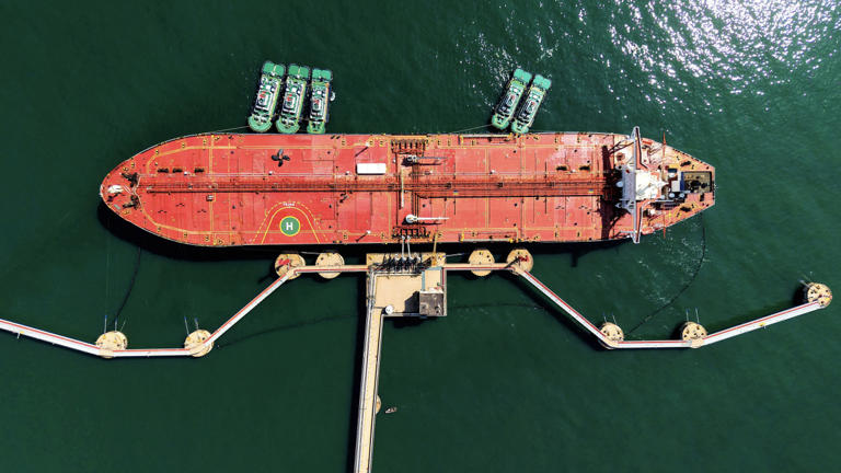 An oil tanker unloads crude oil at the port of Qingdao, in China's eastern Shandong province..