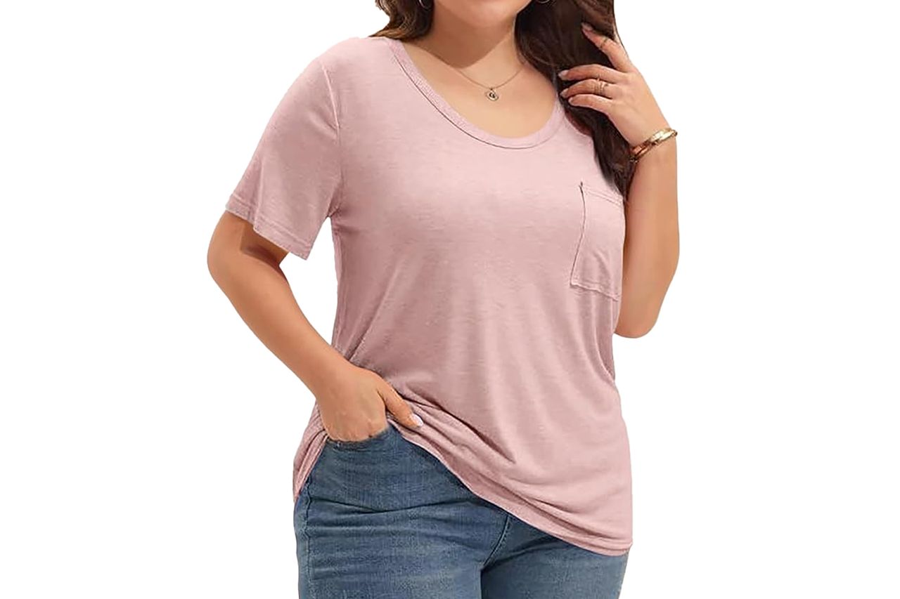 A woman wearing a casual tunic Tshirt and jeans posing with one hand on her hip