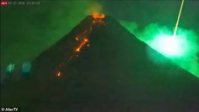 Incredible moment a meteor streaks through the sky over an erupting ...