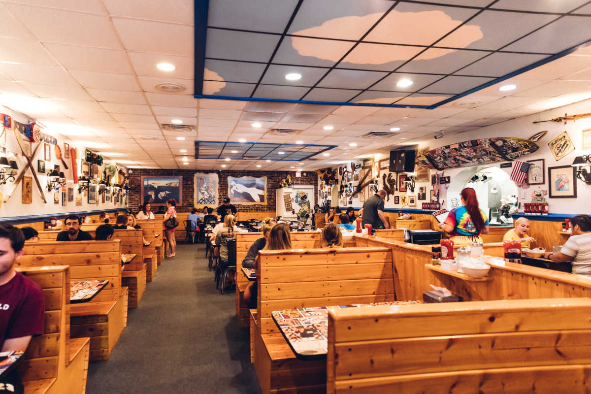 Chicken or the egg interiors with people seated at wooden booths