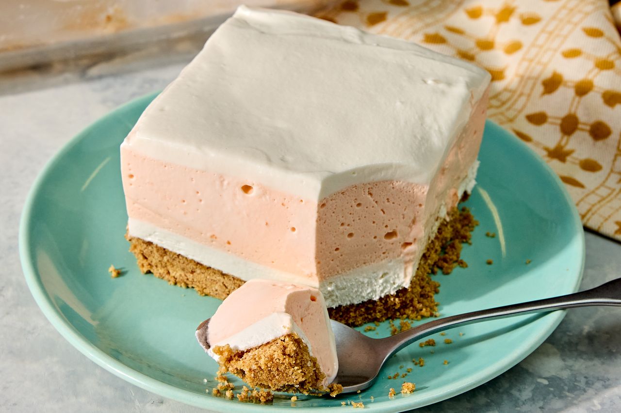 Nobake orange creamsicle bar dessert served on a plate with one cut out piece on a spoon