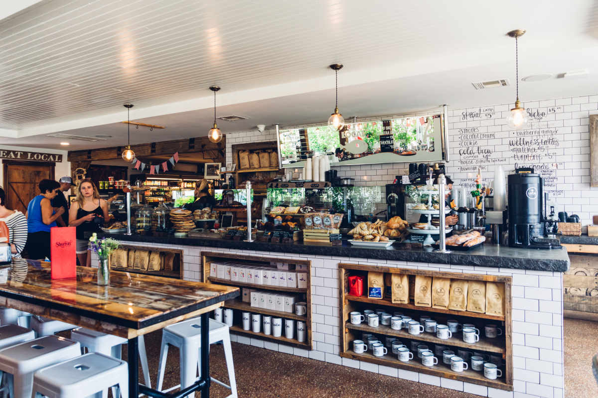 The Local interiors with white tile walls and pastries behind glass on the counter