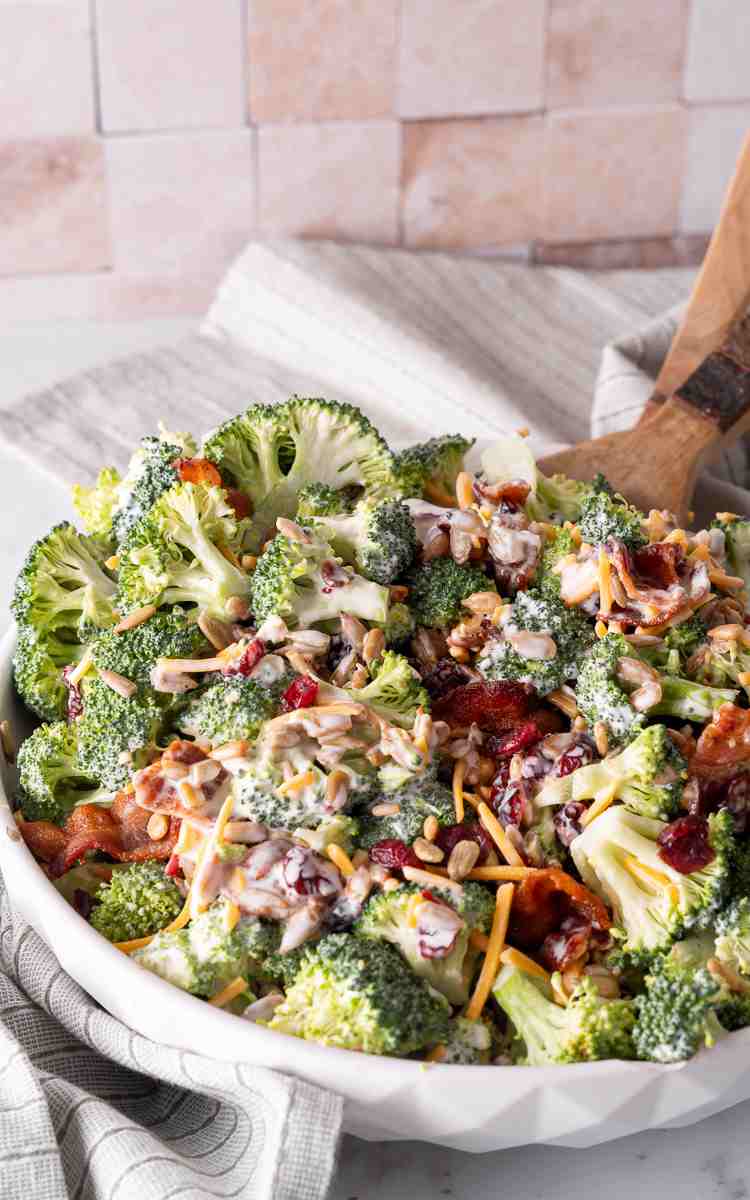 Broccoli Salad with Bacon and serving utensils in a bowl.