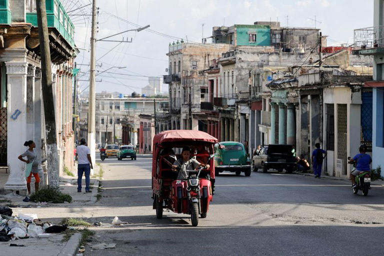 FOTO DE ARCHIVO: Un hombre conduce un rickshaw eléctrico a lo largo de una avenida mientras la red eléctrica de Cuba sufrió un colapso parcial la madrugada del jueves, cortando la energía en todo el este de Cuba en medio de un bloqueo de combustible de Estados Unidos, en La Habana, Cuba, 14 de mayo de 2026. REUTERS/Norlys Perez/File Photo