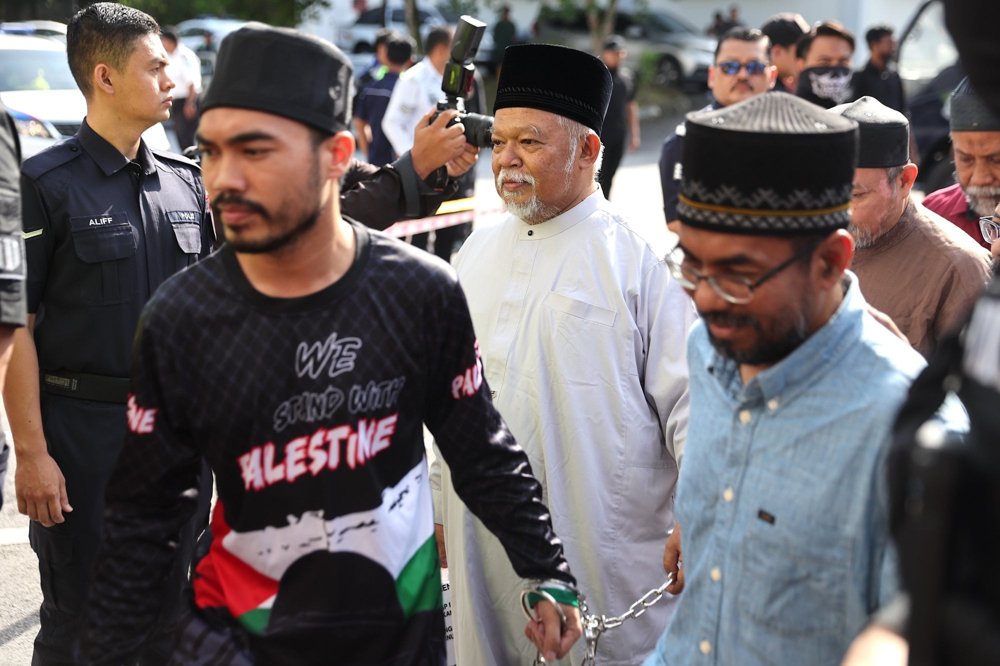 Royal Malaysian Police officers escort GISBH CEO Nasiruddin Mohd Ali (centre) and other members as they arrive to face charges for organised crime at the Selayang court in Malaysia in October 2024. Photo: EPA-EFE