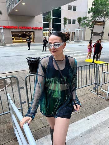 reviewer wearing the black shorts beneath sheer green mesh dress