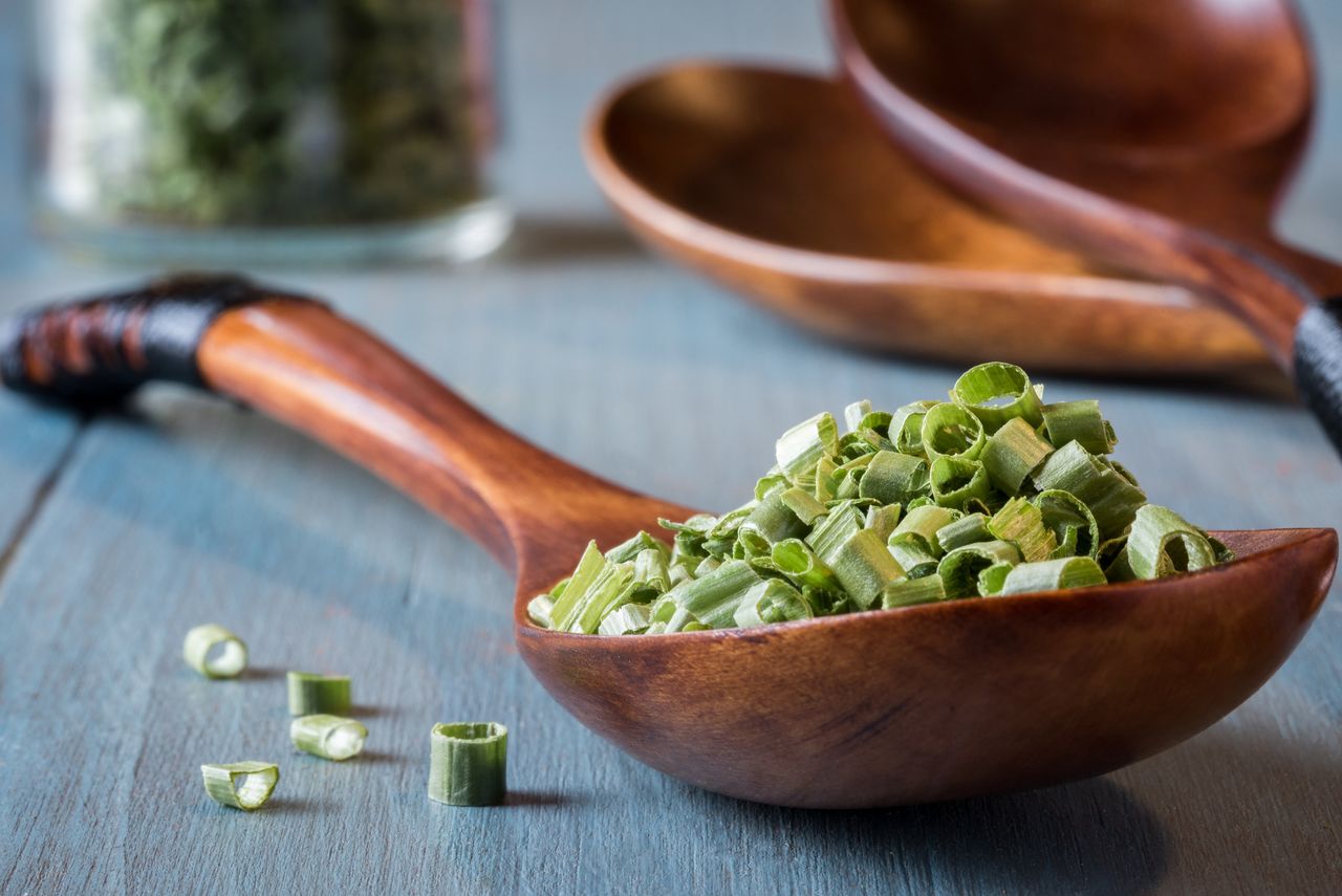 Dried chives in a wood spoon
