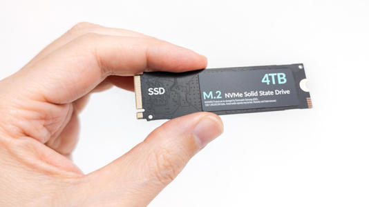 A person holding a 4TB SSD in front of a white background