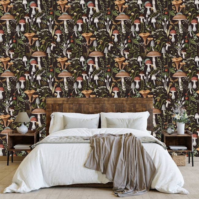 Bedroom with a wooden bed, white bedding, and mushroom-patterned wallpaper, creating a cozy and stylish atmosphere