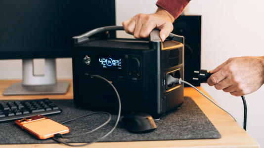 A person hooking up their PC to a UPS