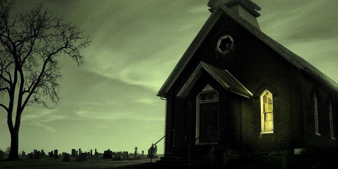 An ominous-looking church with one light on in the window in Revival book cover