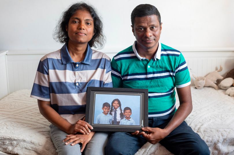 Chamila and Rasika holding a photo of their children