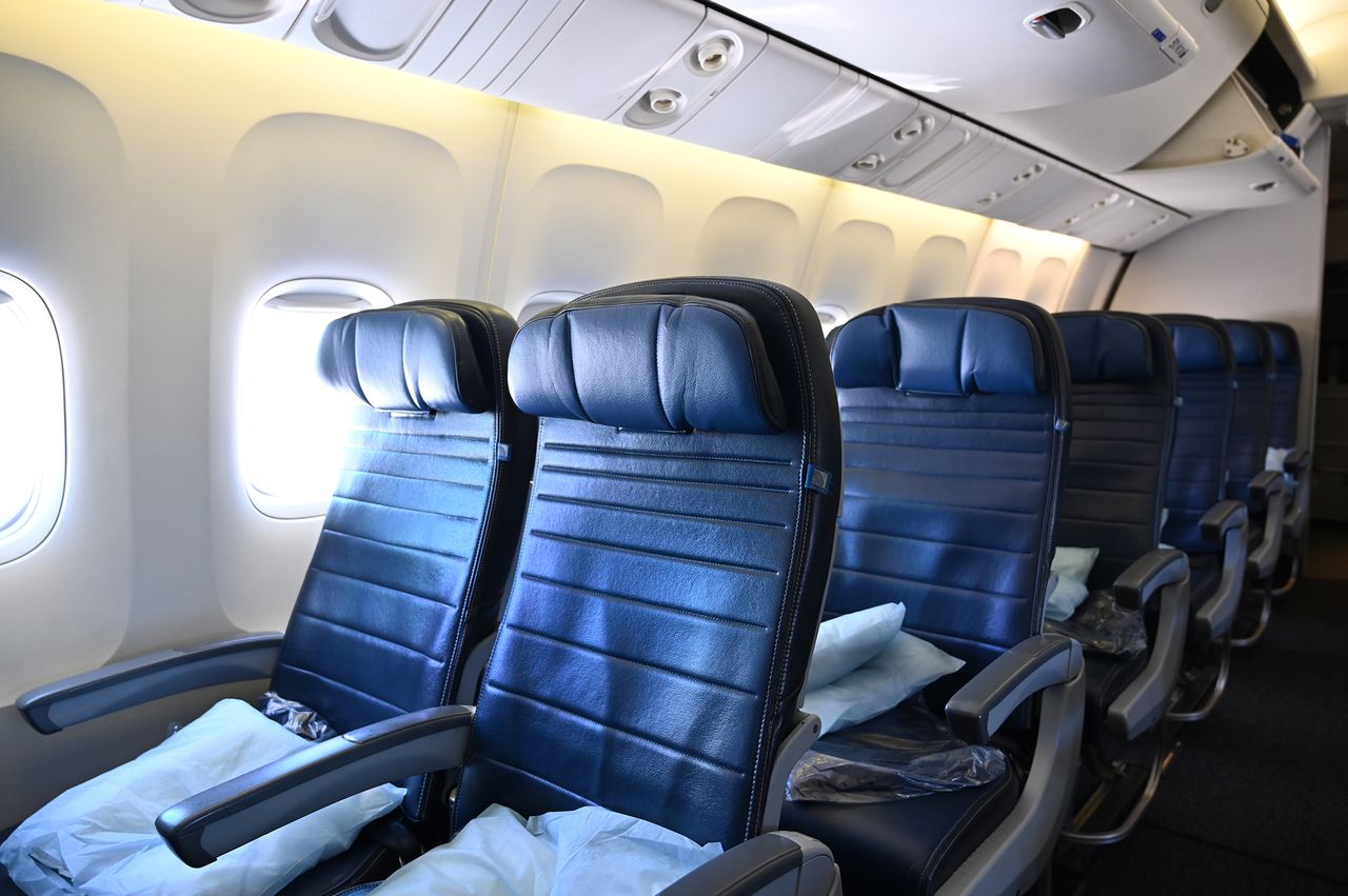 Airplane cabin showing empty seats in an economy class configuration