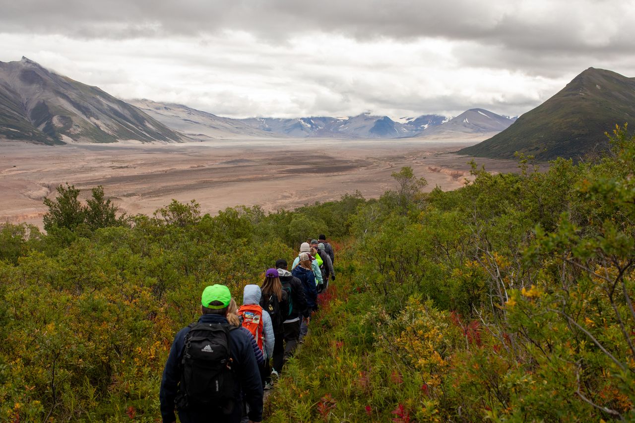 Group hiking on a trail in a valley surrounded by mountains