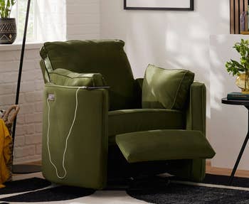 Cozy living room with a recliner chair, modern abstract art, a floor lamp, and a side table with plant decor; ideal for home relaxation