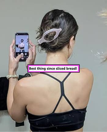 reviewer in workout attire takes a mirror selfie, highlighting a large hair clip. Text: