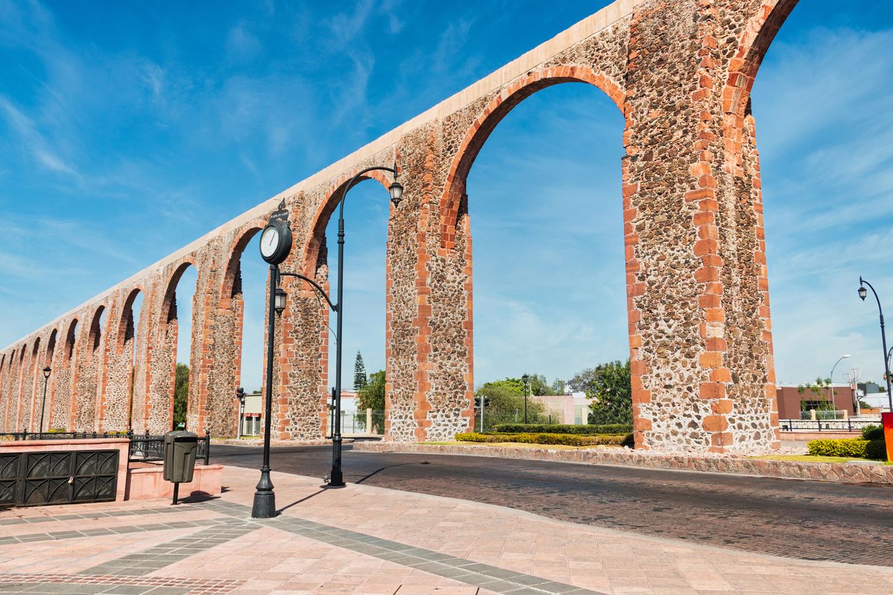 The Aqueduct of Quertaro a historic stone aqueduct structure with arches over a city street in Quertaro Mexico