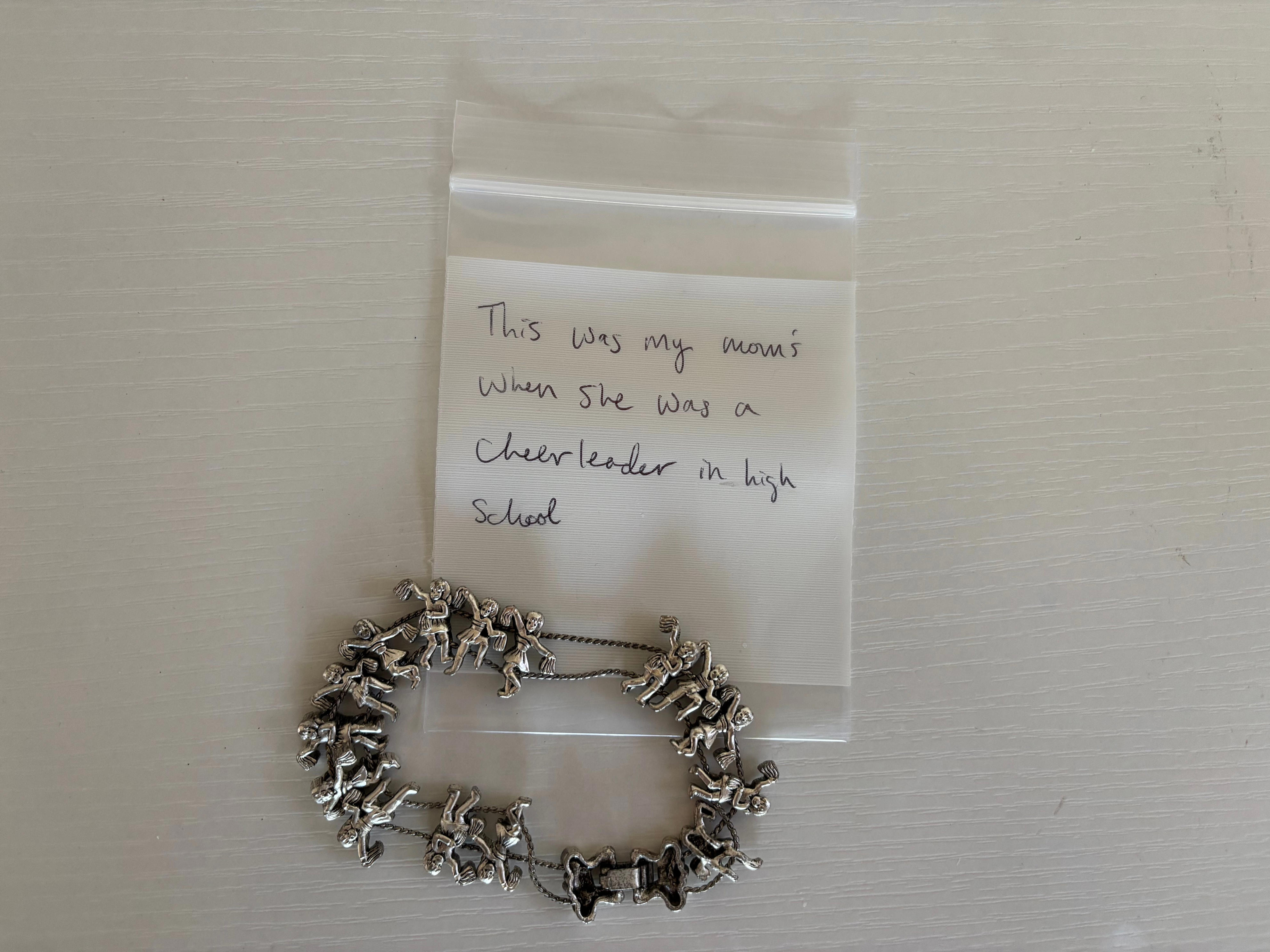 A charm bracelet with a plastic bag, that says
