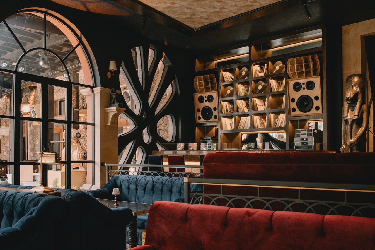 Interior view of a stylish restaurant with artistic shelving and comfortable seating arrangements