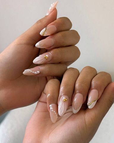 A sheer manicure with pearl nail art and 3D accents.