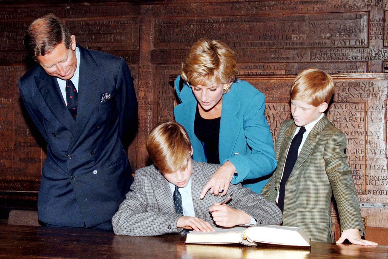 Prince William signs in on his first day at Eton College watched by his parents, he Prince and Princess of Wales and brother, Prince Harry on September 6, 1995 in Windsor, England.