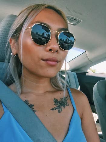 Reviewer wearing the round sunnies, which have black frames and gold rims
