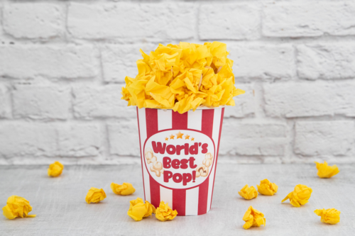 A striped popcorn container labeled