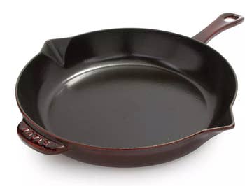 A cast iron skillet with a pour spout and handle, suitable for cooking
