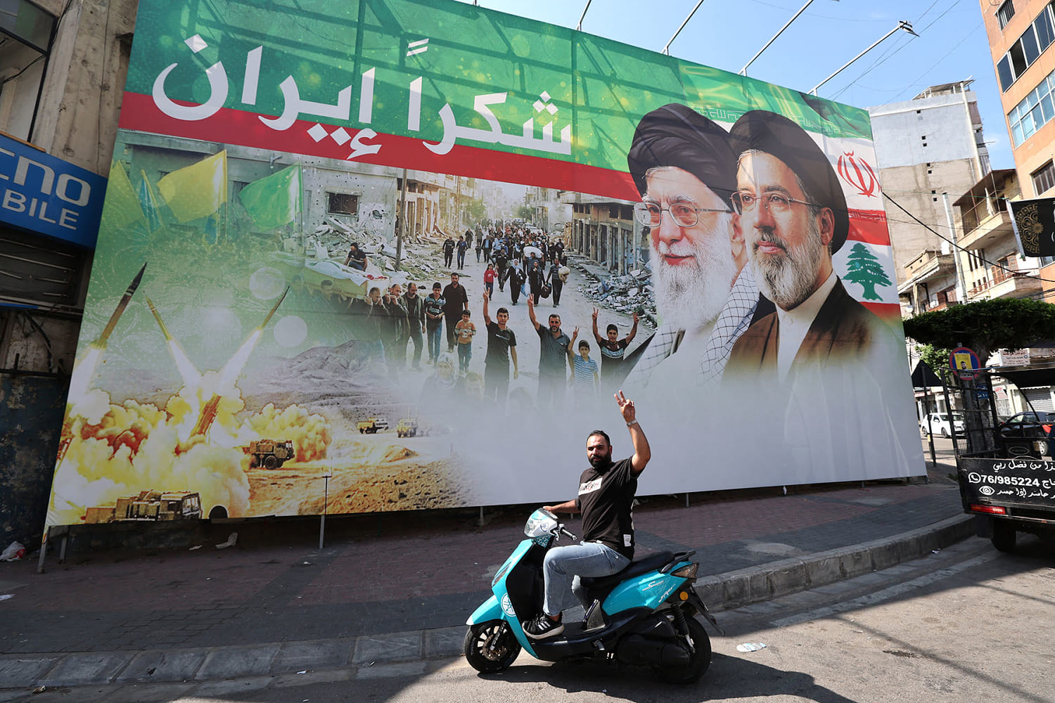 A man flashes the victory sign in front of a billboard depicting the late Iranian leader Ayatollah Ali Khamenei and Iranian Supreme Leader Ayatollah Mojtaba Khamenei in Beirut, Lebanon. (Anwar Amro / AFP via Getty Images)