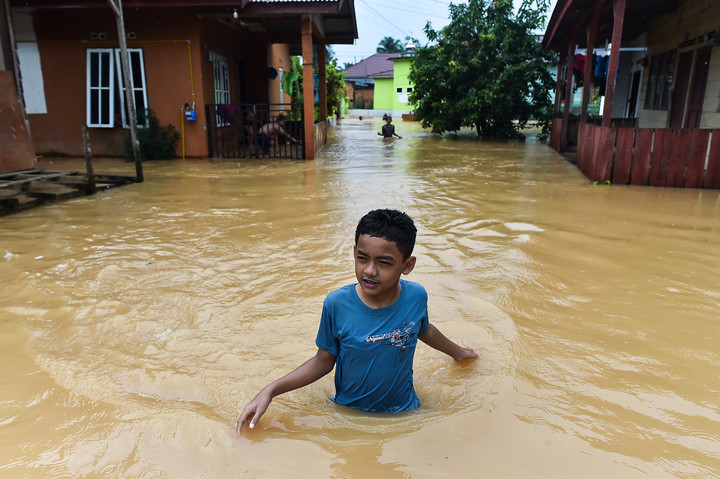 Seorang anak menerobos jalan kawasan permukiman yang terendam banjir di Kenali Asam Bawah, Kota Baru, Jambi, Kamis (18/6/2026). Foto: Wahdi Septiawan/ANTARA FOTO