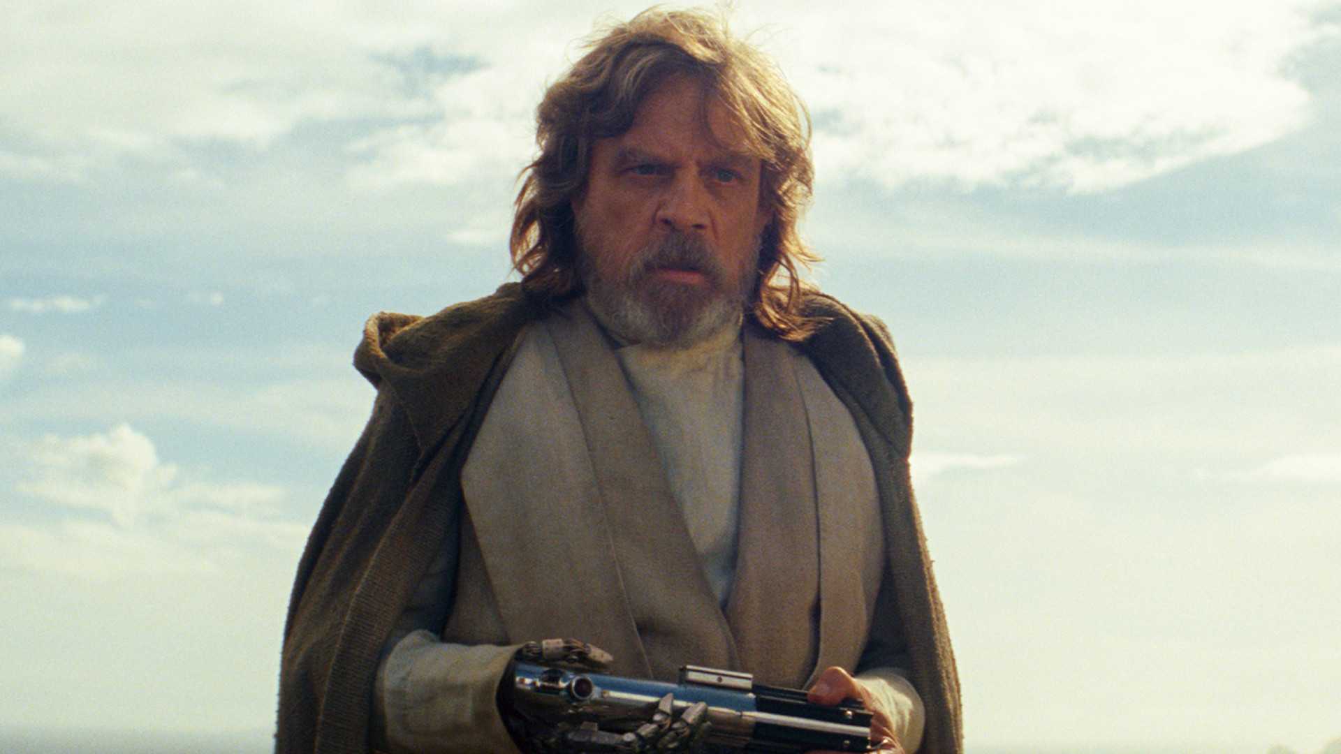 Mark Hamill as Luke Skywalker holding a lightsaber in Star Wars: The Last Jedi