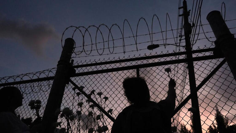 This file photo shows people placing flowers on a fence outside Krome Detention Center in Miami on May 24, 2025, during a vigil to recognise people who died in US Immigration and Customs Enforcement custody as well as those affected by mass deportations.