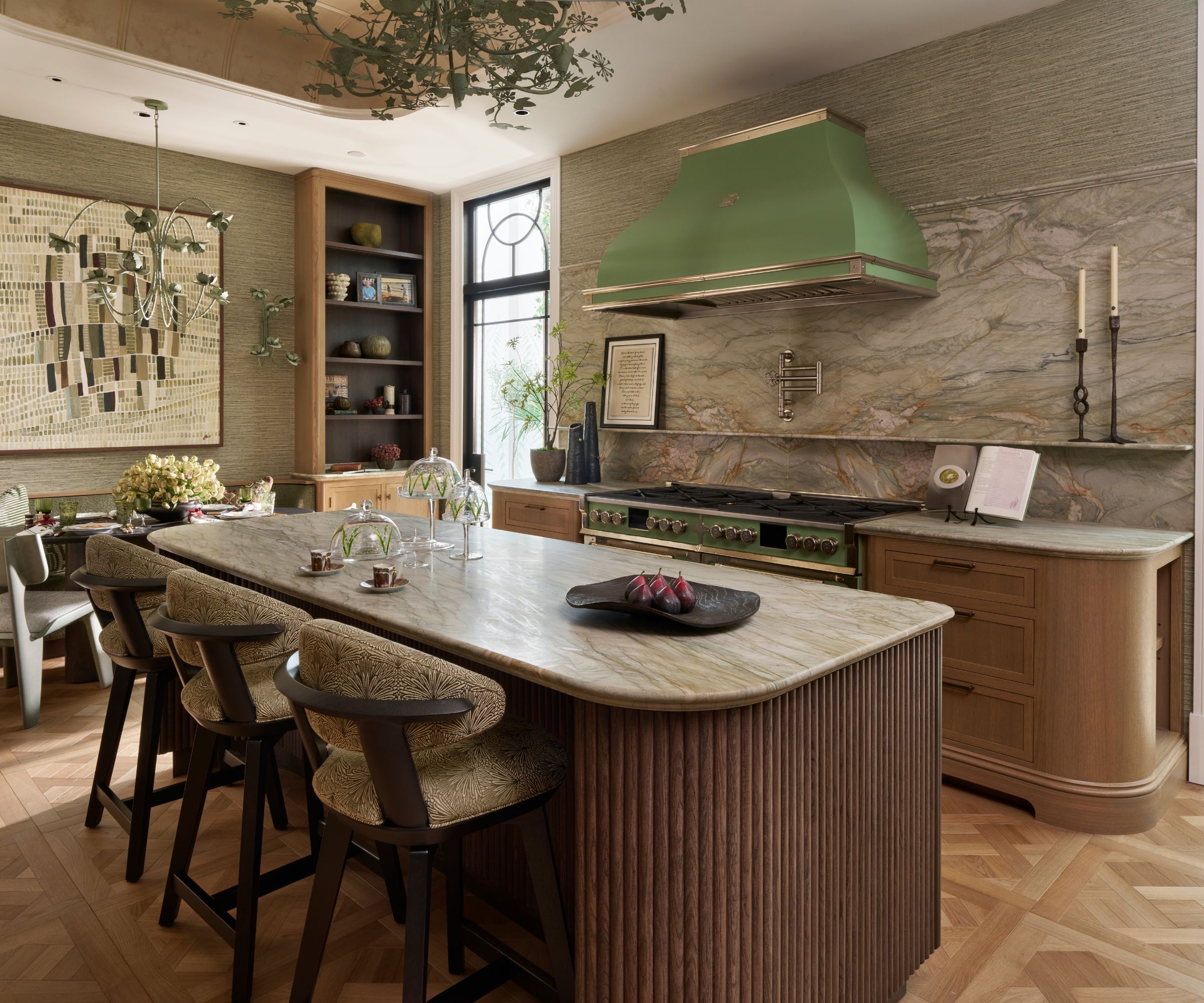 A wooden kitchen with marble countertops and a green range hood