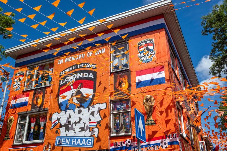 A street in The Hague is drenched in orange as Netherlands soccer fans ...