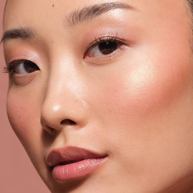 Close-up of a person's face showcasing smooth, radiant skin with natural makeup, highlighting a beauty or skincare product feature