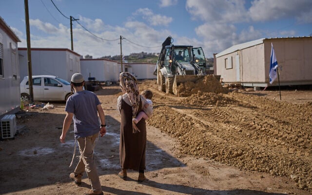 Israeli settlers walk through the newly-legalized Jewish settlement of Yatziv, adjacent to the Palestinian town of Beit Sahour, in the West Bank, January 19, 2026. (AP Photo/Ohad Zwigenberg)